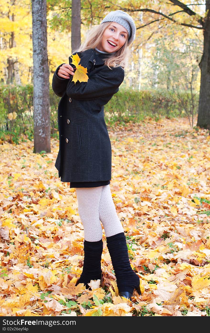 Beautiful young woman in autumn foliage