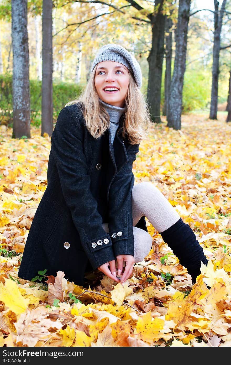 Beautiful young woman in autumn foliage