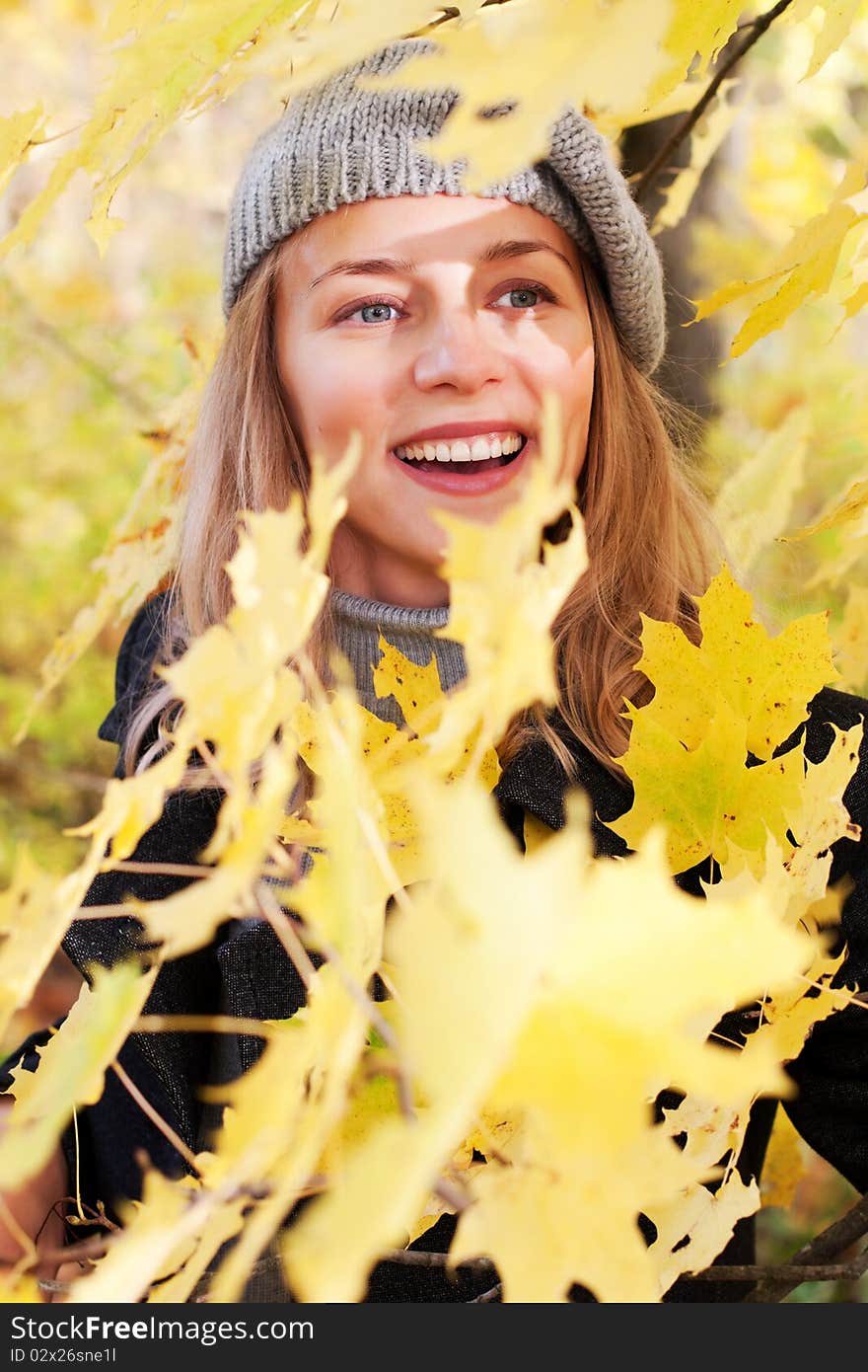 Beautiful young woman in autumn foliage