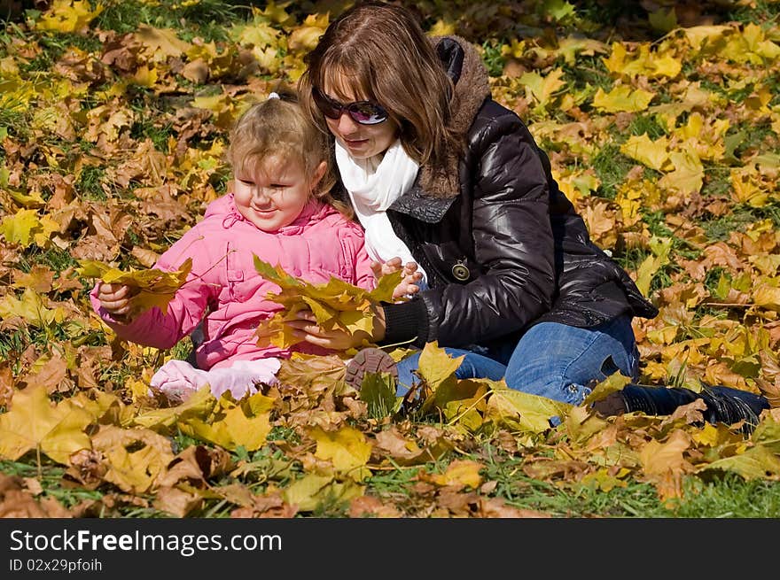 Mama with a daughter in autumn park