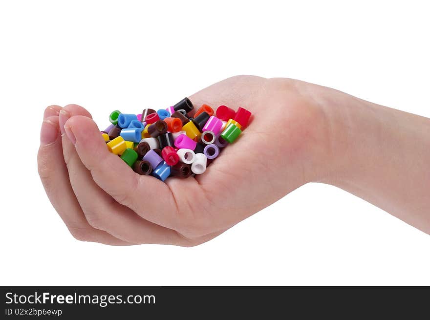 Plastic colorful mosaic particles in the child hand isolated over white background. Plastic colorful mosaic particles in the child hand isolated over white background