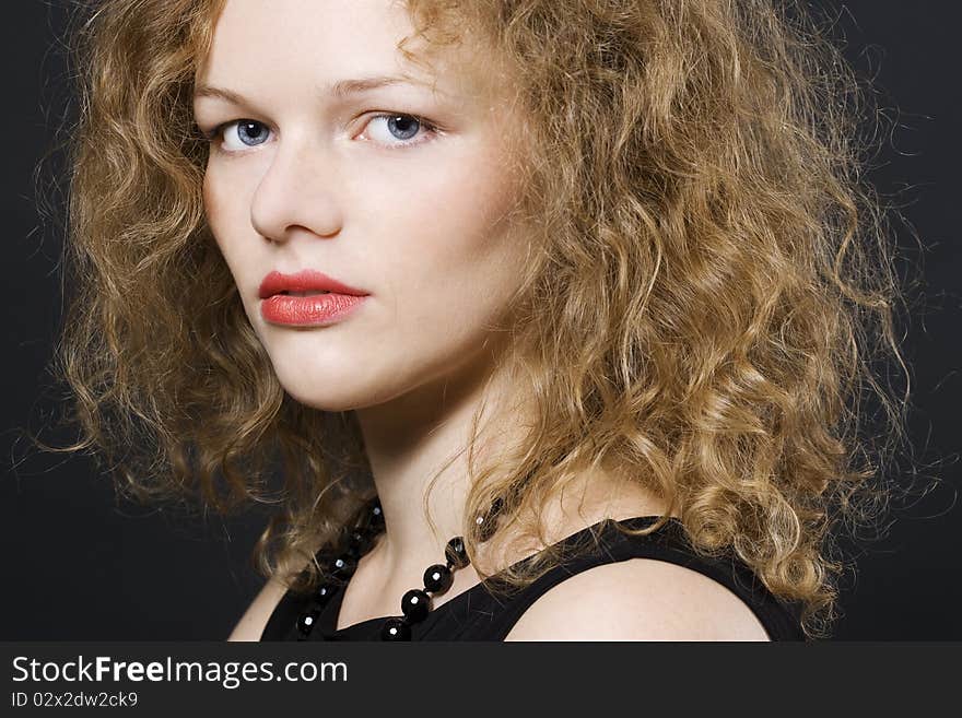 Image of beautiful young woman with curly hairs looking at camera