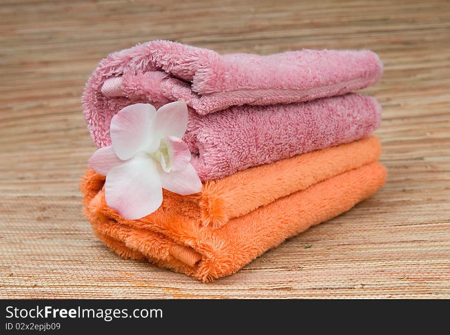 Two rolled towels and flower pink orchid. Two rolled towels and flower pink orchid