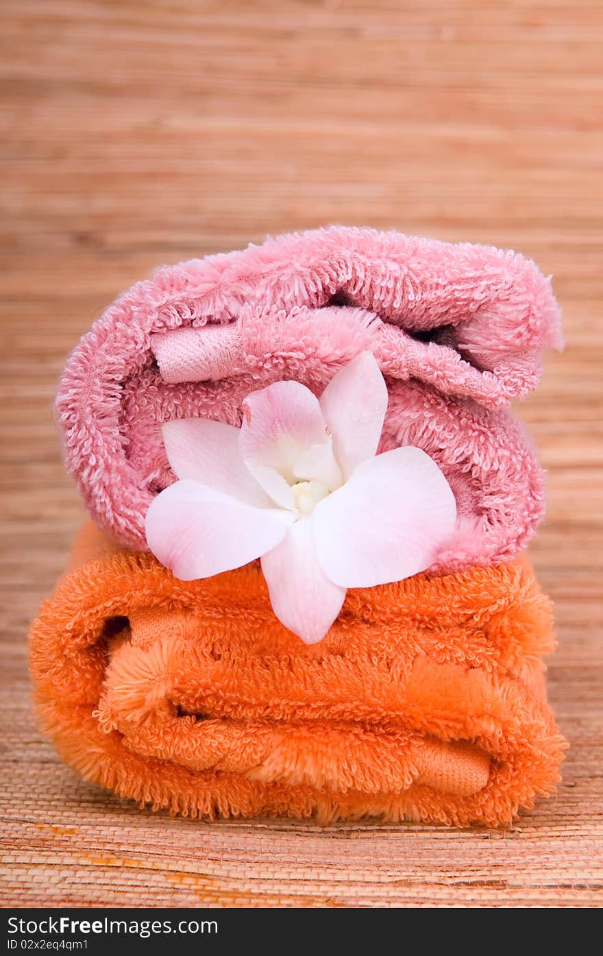 Two rolled towels and flower pink orchid. Two rolled towels and flower pink orchid