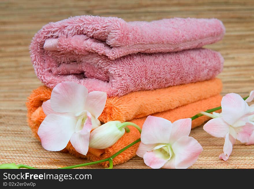 Two rolled towels and flower pink orchid. Two rolled towels and flower pink orchid