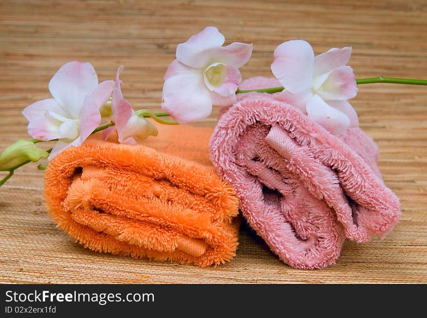 Two rolled towels and flower pink orchid. Two rolled towels and flower pink orchid