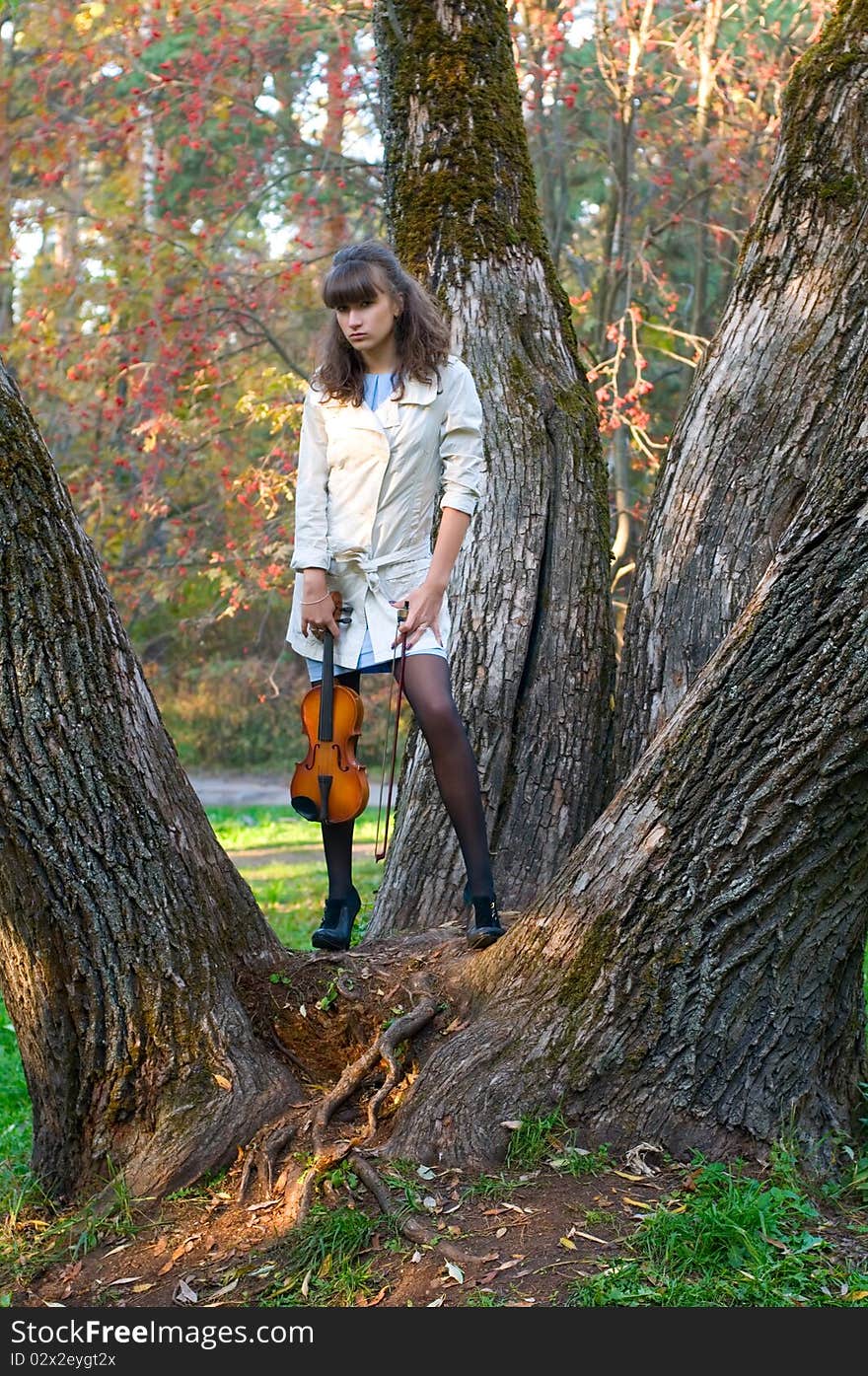 The young woman with a violin listens to music of autumn. The young woman with a violin listens to music of autumn