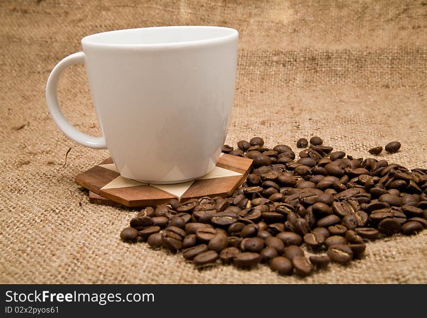 Grains and cup of coffee on a background rough material