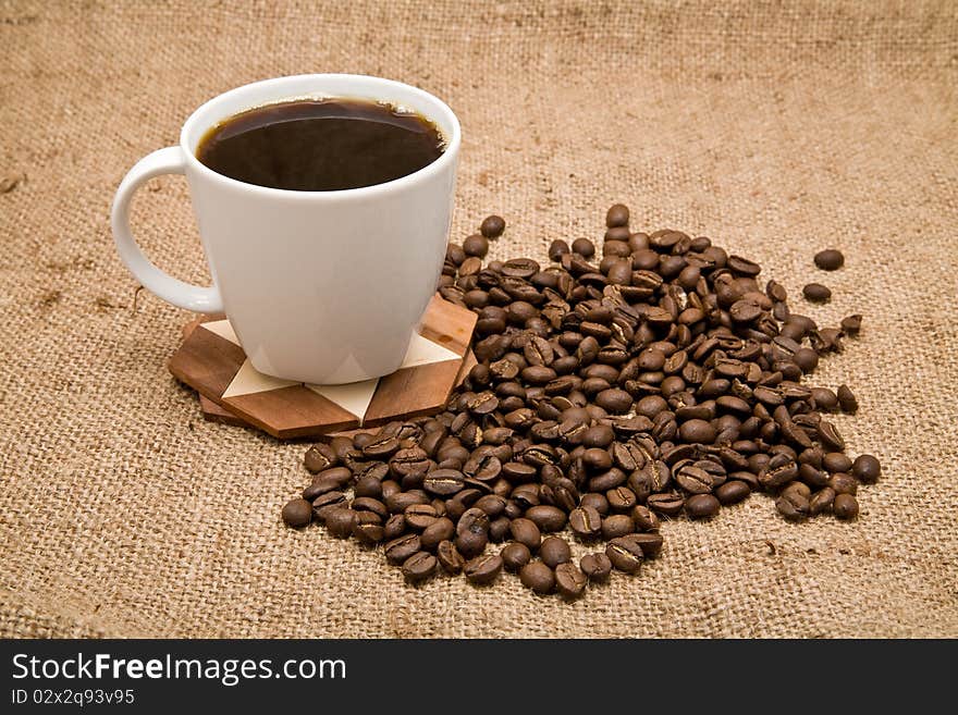 Grains and cup of coffee on a background rough material