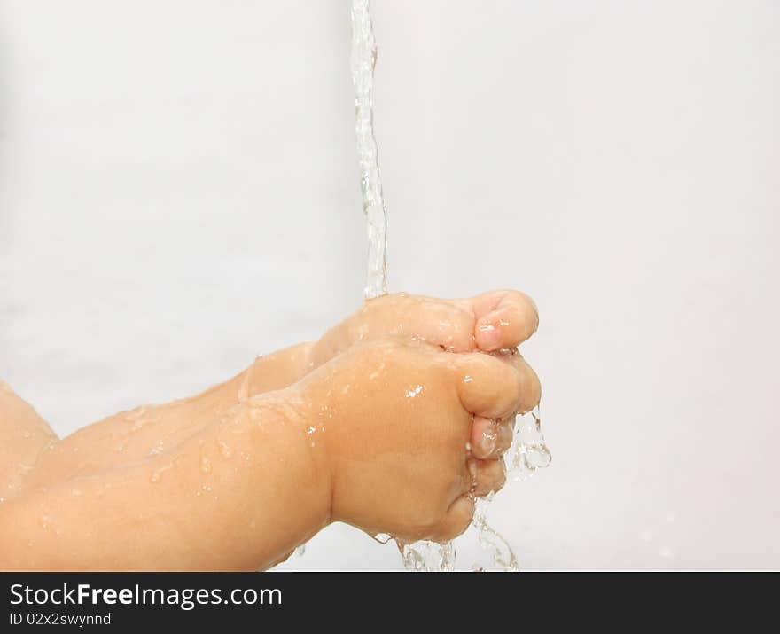 Child washes his hands under running water