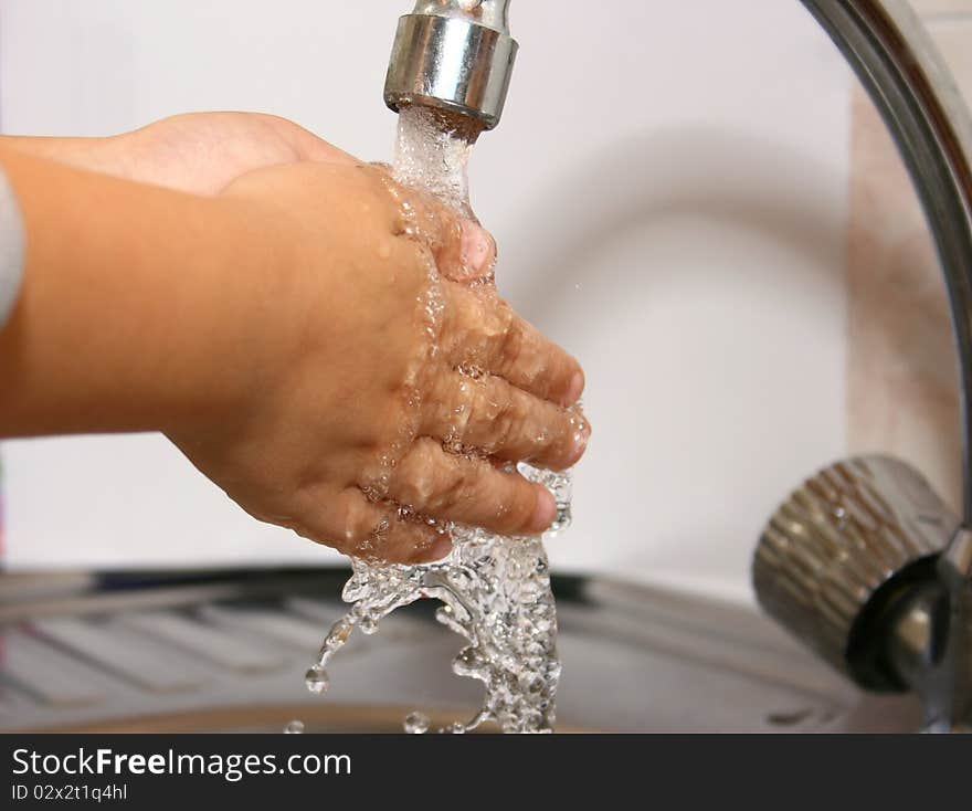 The Little Boy Washes Hands In A Bathroom