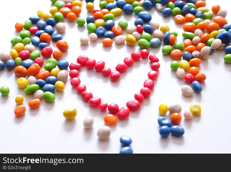 Coloured candies, from red a heart is laid out