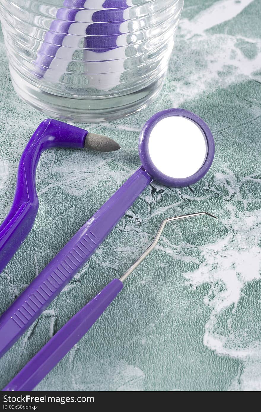 Dental stain eraser, dental mirror, and dental pik on the green countertop. Dental stain eraser, dental mirror, and dental pik on the green countertop.