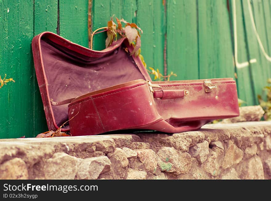 Vintage weathered leather suitcase in the street