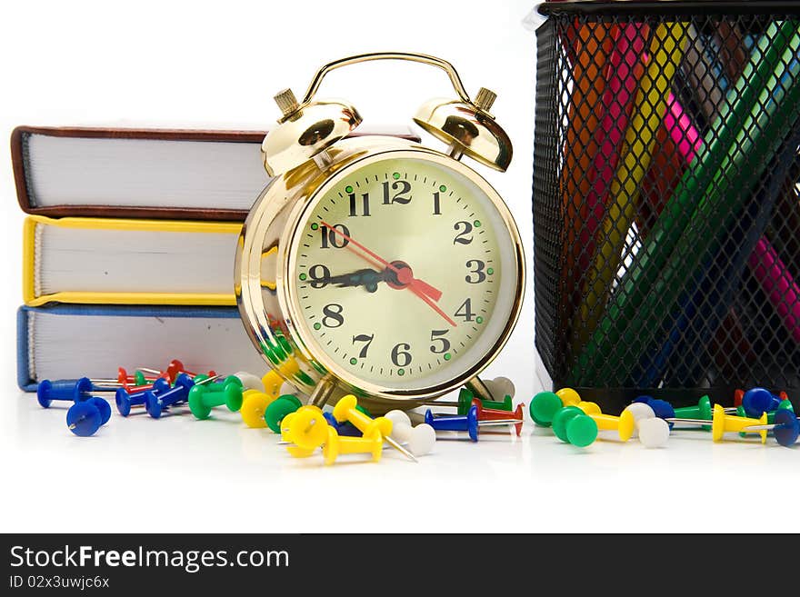 Books, clock and pencils on a white background