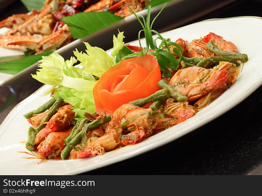 A dish of spicy chili prawn served with garnishing and tomato