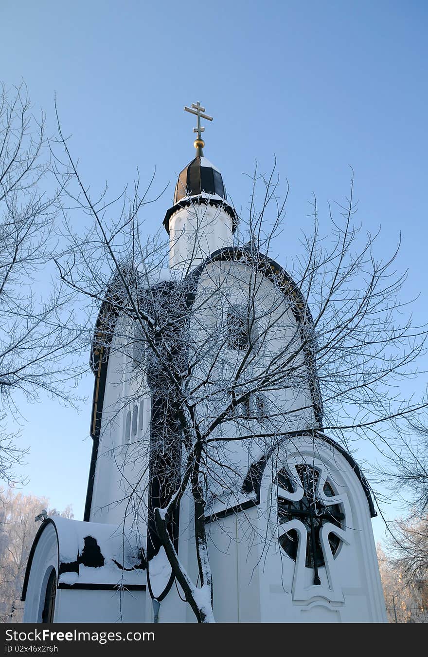 Portion of little white chapel in the background of the blue sky in the town of Korolev near Moscow in Russia. Portion of little white chapel in the background of the blue sky in the town of Korolev near Moscow in Russia