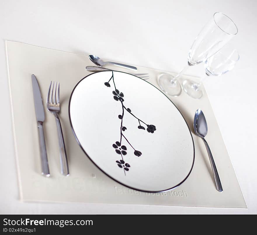 A dinner plate, knife, spoon and fork