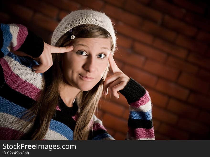 Cute girl making funny smile on the brick wall. Cute girl making funny smile on the brick wall