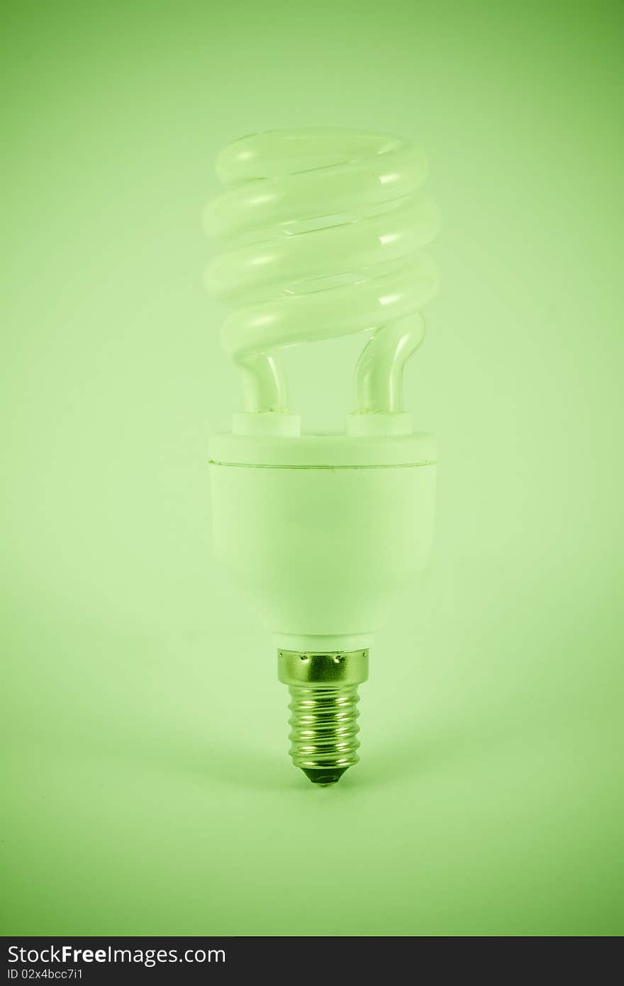 Energy saving light bulb whit a green light. Isolated on white background.