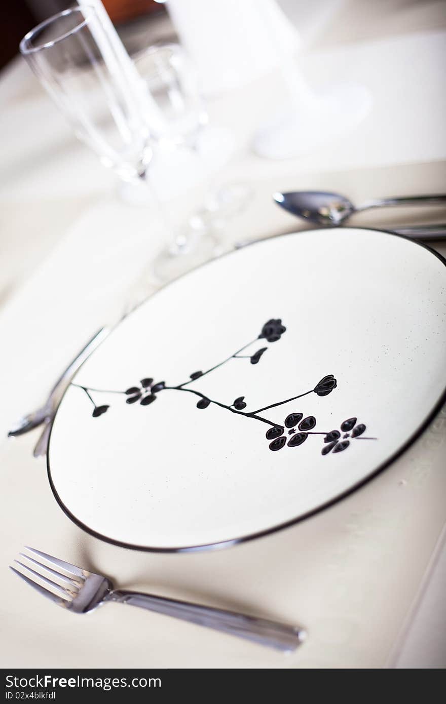 A dinner plate, knife, spoon and fork