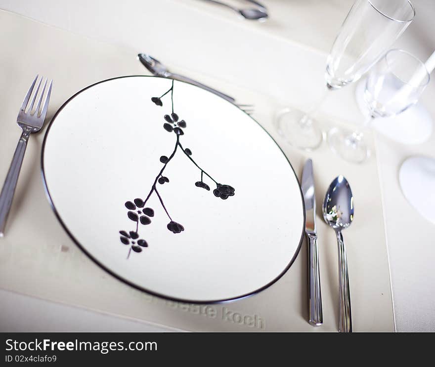 A dinner plate, knife, spoon and fork