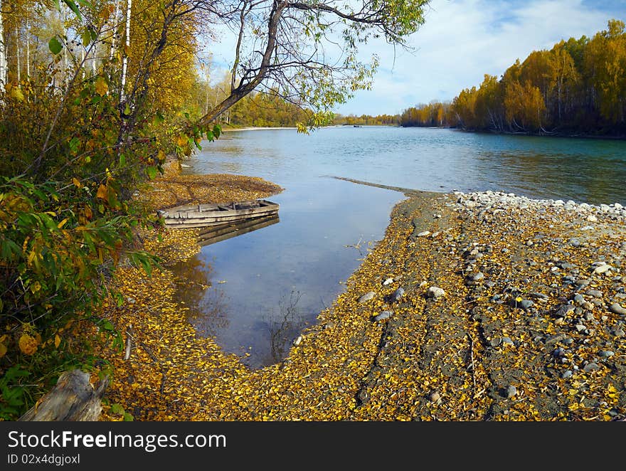 Autumn mountain river scenic with wooden boat. Autumn mountain river scenic with wooden boat