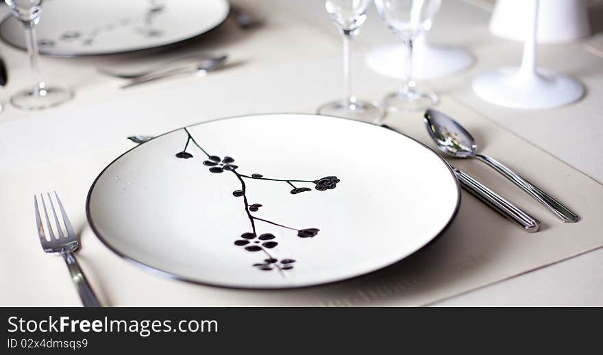 A dinner plate, knife, spoon and fork