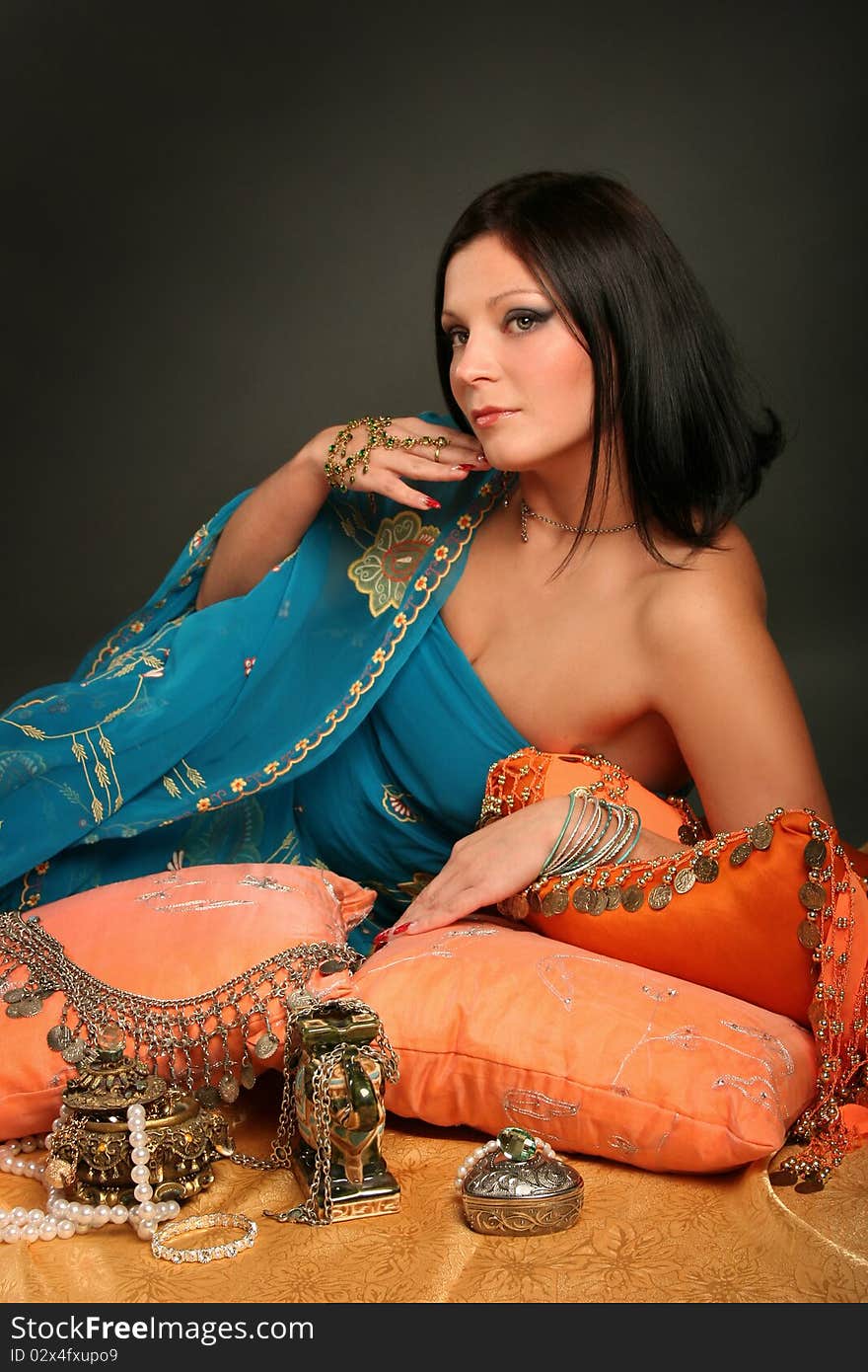 Beautiful indian woman laying in ethnic interior