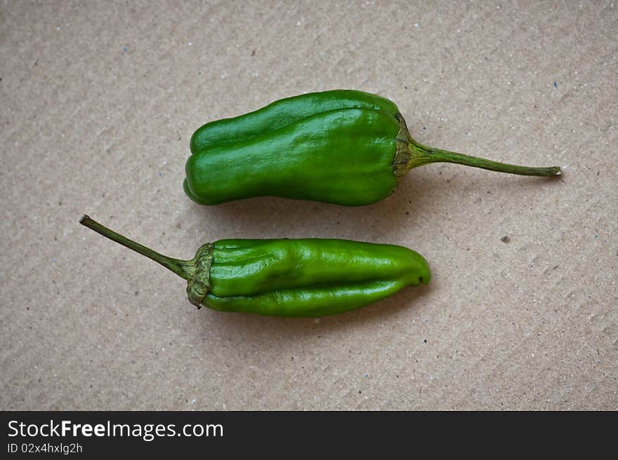 Two Hot Jalapeño peppers on a carton background. Two Hot Jalapeño peppers on a carton background