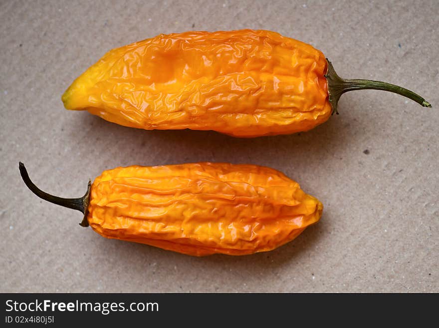 Two hot chili peppers on a cardboard background. Two hot chili peppers on a cardboard background