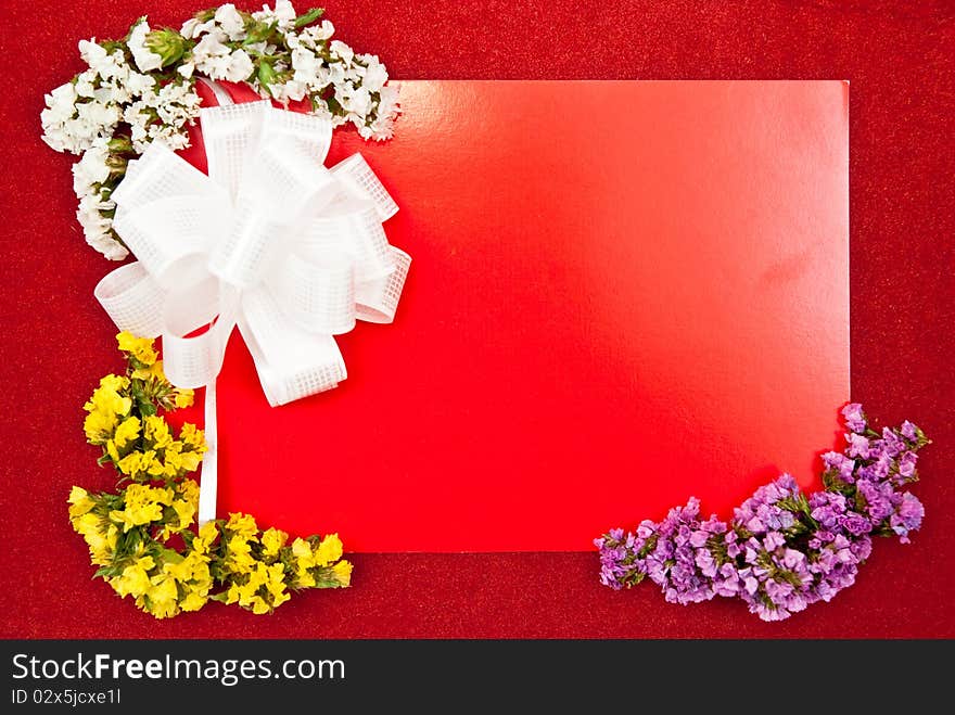 Greeting card with bow and flowers on red background