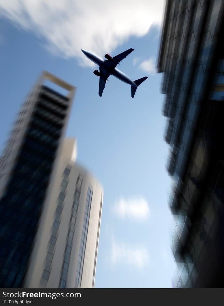 Aircraft flies over tower blocks with zoom effect. Aircraft flies over tower blocks with zoom effect