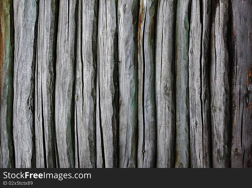 Fence from logs. Backgrounds. Old wooden fence.