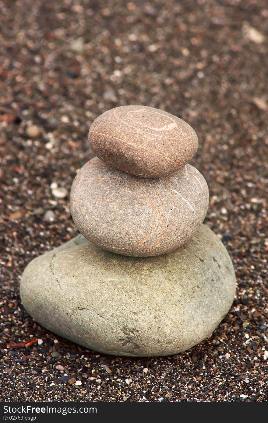 Pyramid of three stones on sand