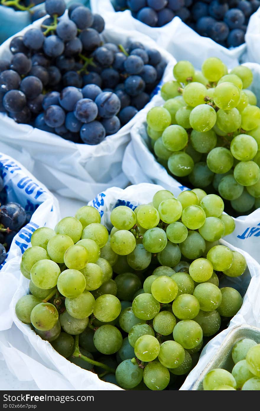 Concord and Green grapes for sale at a farmer's market. Concord and Green grapes for sale at a farmer's market