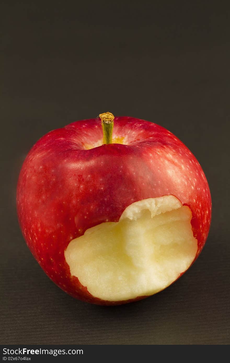 Red apple with firm, metaphoric bite taken from its flesh. Red apple with firm, metaphoric bite taken from its flesh