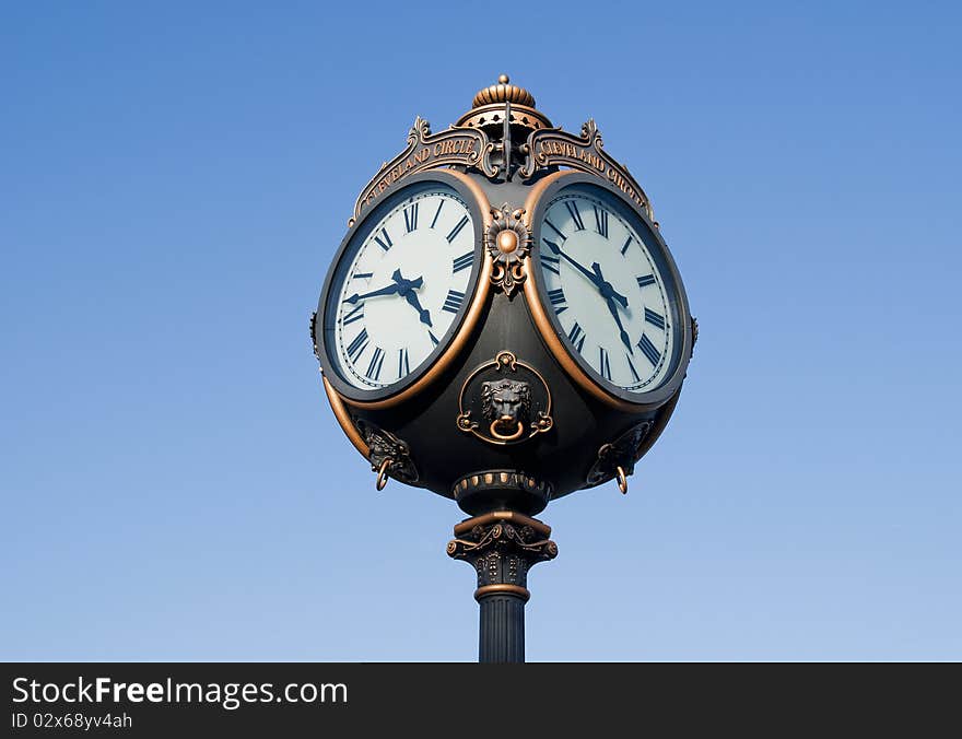 Outdoor round four faced clock on blue with clipping path. Outdoor round four faced clock on blue with clipping path