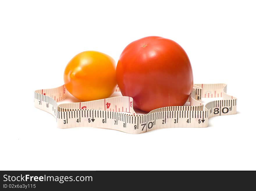 Measuring tape around a red and yellow tomatoes.