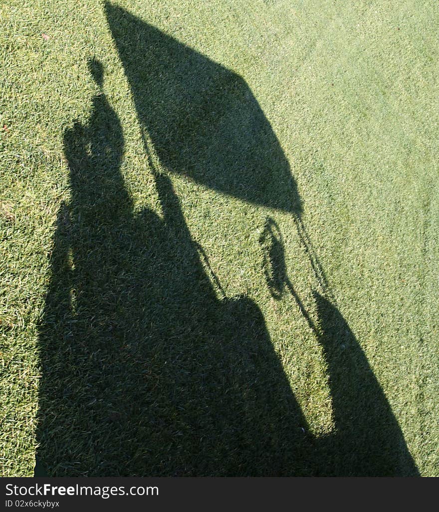 Sun creates a golf cart shadow on the fairway