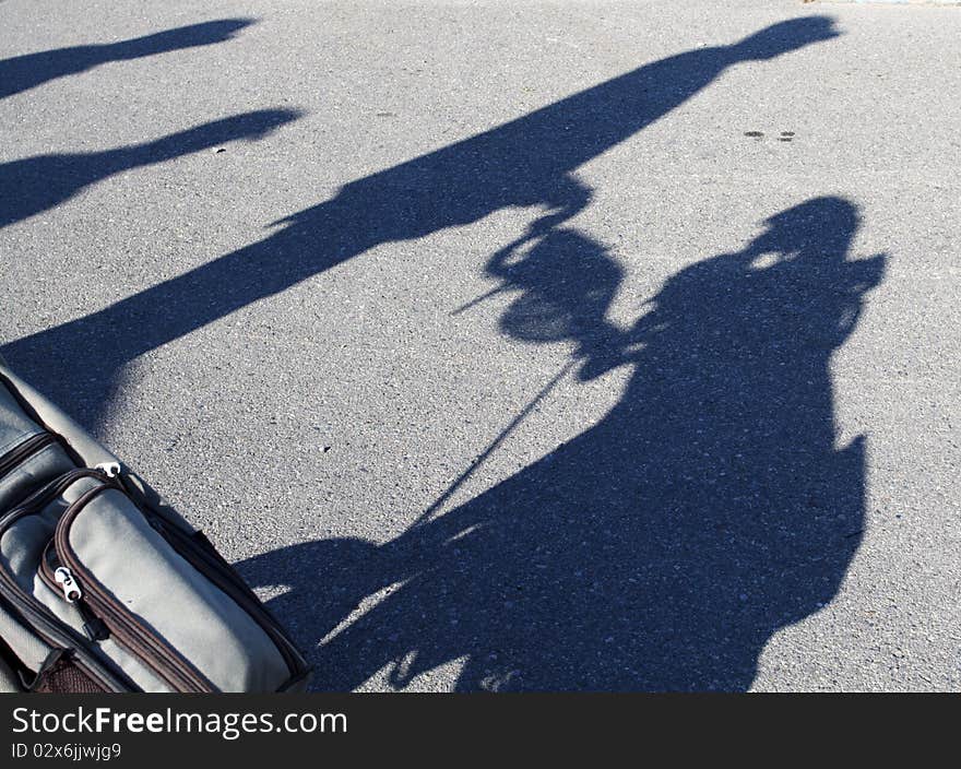 Shadow of a golfer pushing his golf cart. Shadow of a golfer pushing his golf cart