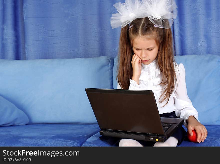 Hard day in learning - girl with laptop and red apple in sofa