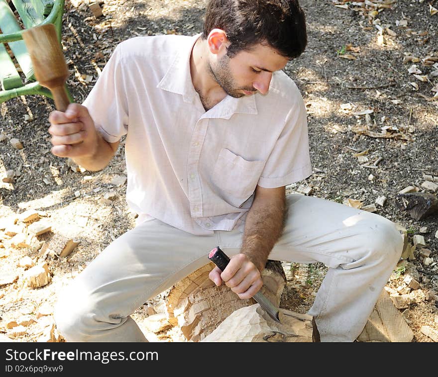 Young man sculpting wood material. Young man sculpting wood material