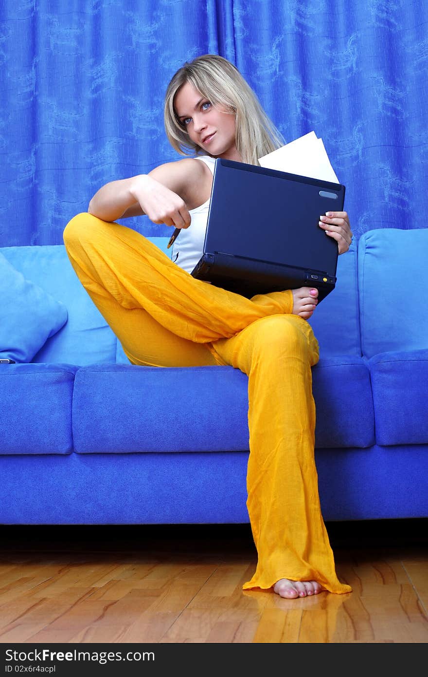Thinking woman working with PC at home in sofa