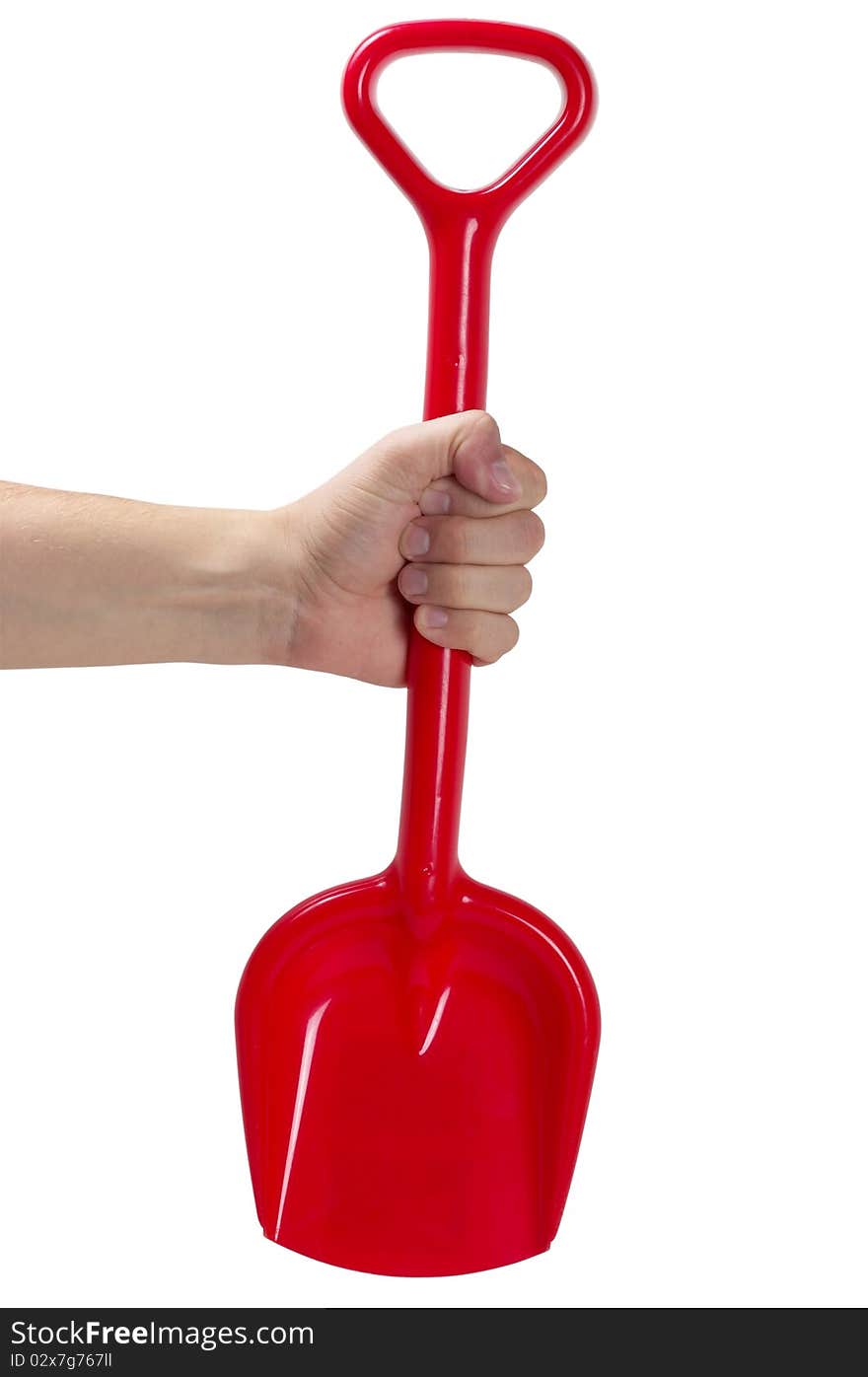 Red plastic toy spade in the hand isolated over white background. Red plastic toy spade in the hand isolated over white background