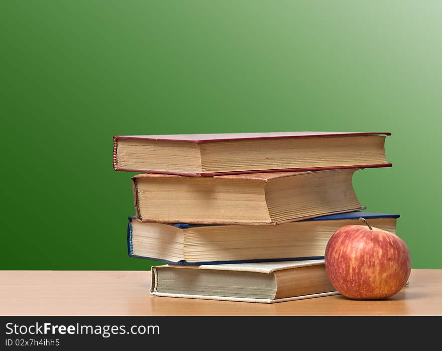 Red apple and books on desk