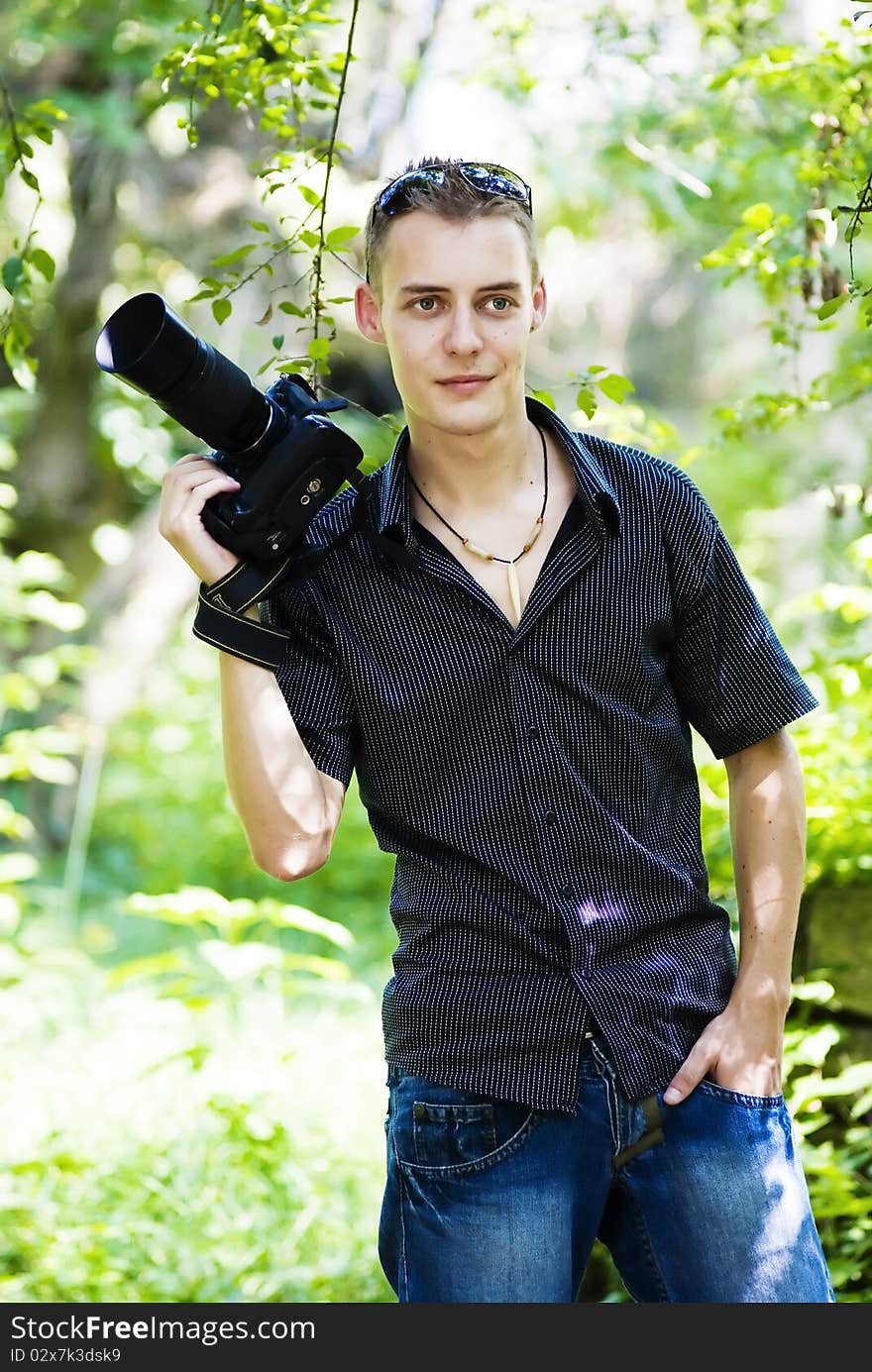 Casual young photographer in the park with camera