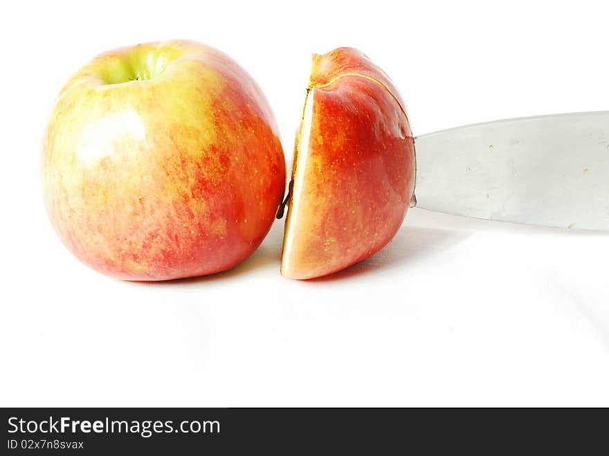 Apples, one of them is a whole second half and it cuts the knife still in half, white background