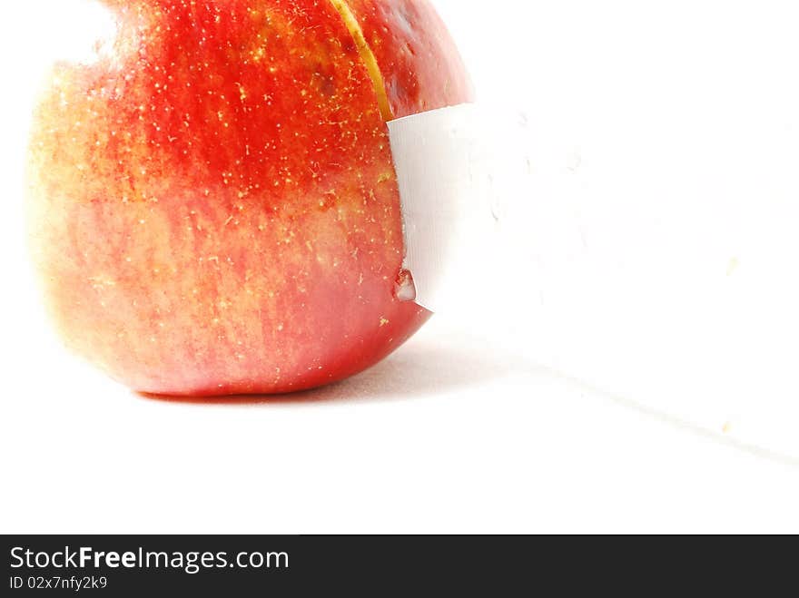 Apple cuts the knife on the tip of a knife drops of juice, white background, still life