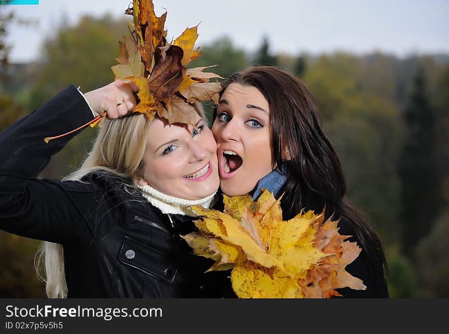 Two Beautiful Girl Friends With Autumn Leafs